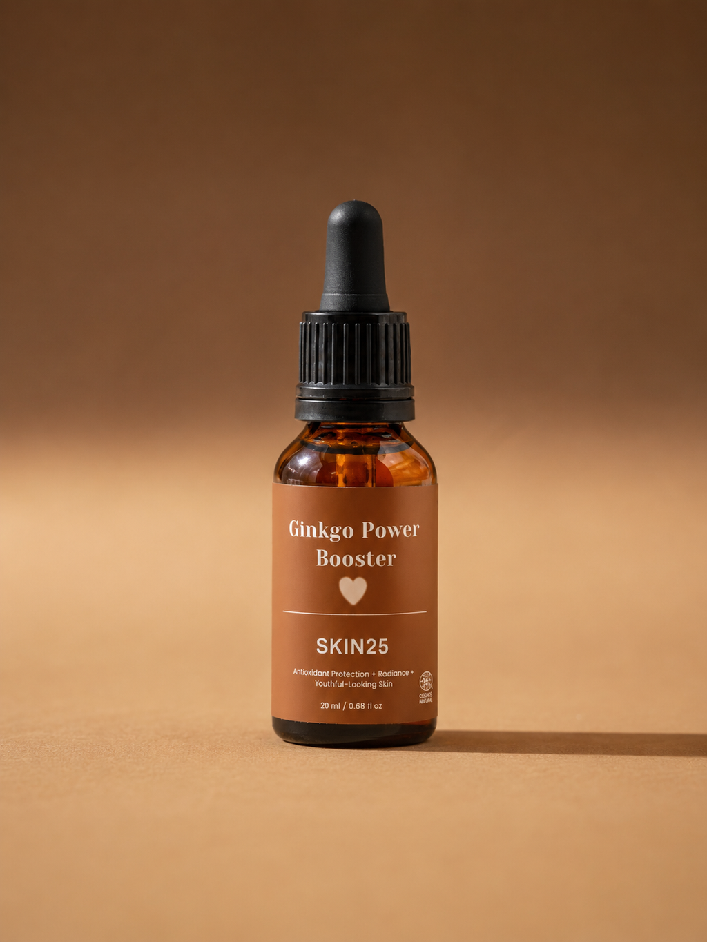 A 20ml amber glass dropper bottle of SKIN25 Ginkgo Power Booster, featuring a black dropper cap and a warm brown label, set against a matching warm brown background.