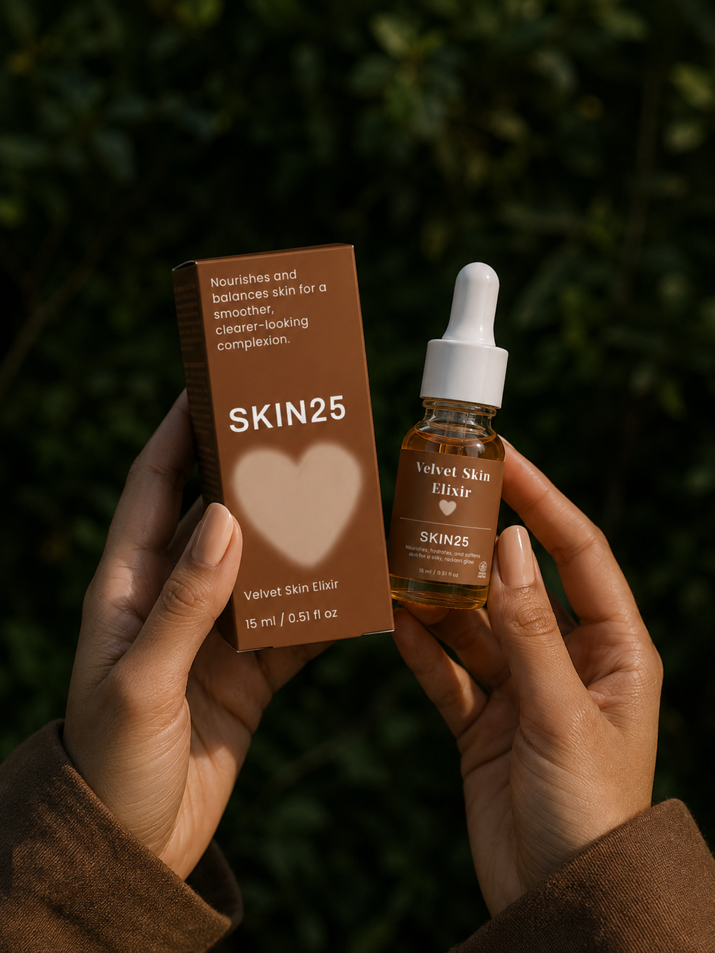 A person holds a brown SKIN25 box and a small amber dropper bottle labeled 'Velvet Skin Elixir' against a blurred green outdoor background.